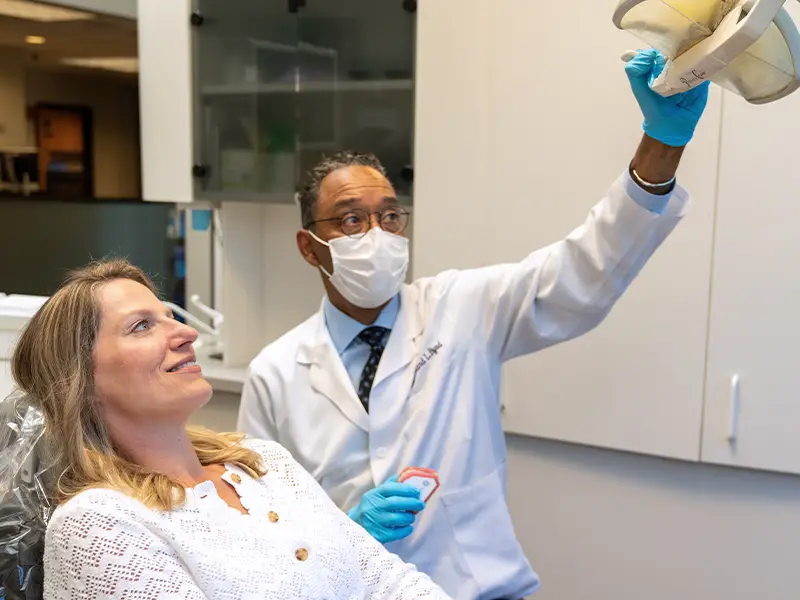 Patient in dentist chair, dentist beginning exam