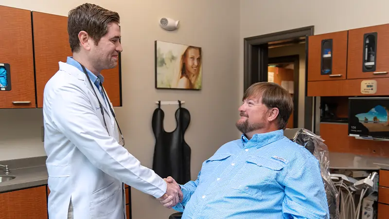 Dentist shaking hands with patient