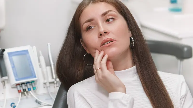 woman with dental emergency in dentist chair
