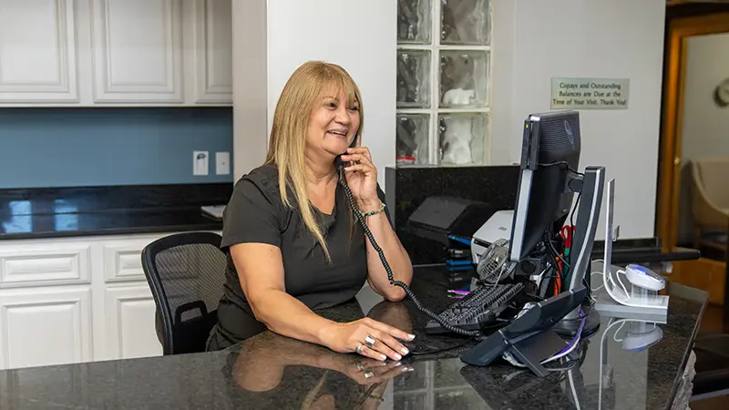 front desk team member on phone with patient