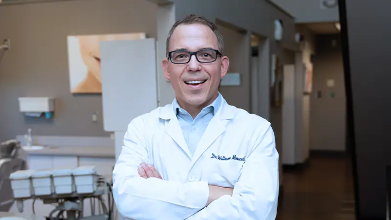Dr. William Monacell, DDS standing in office smiling 