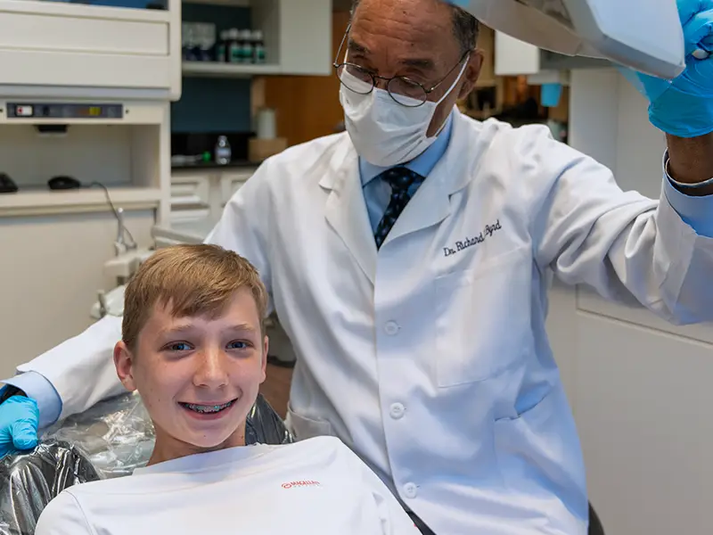 Orthodontist looking at smiling patient