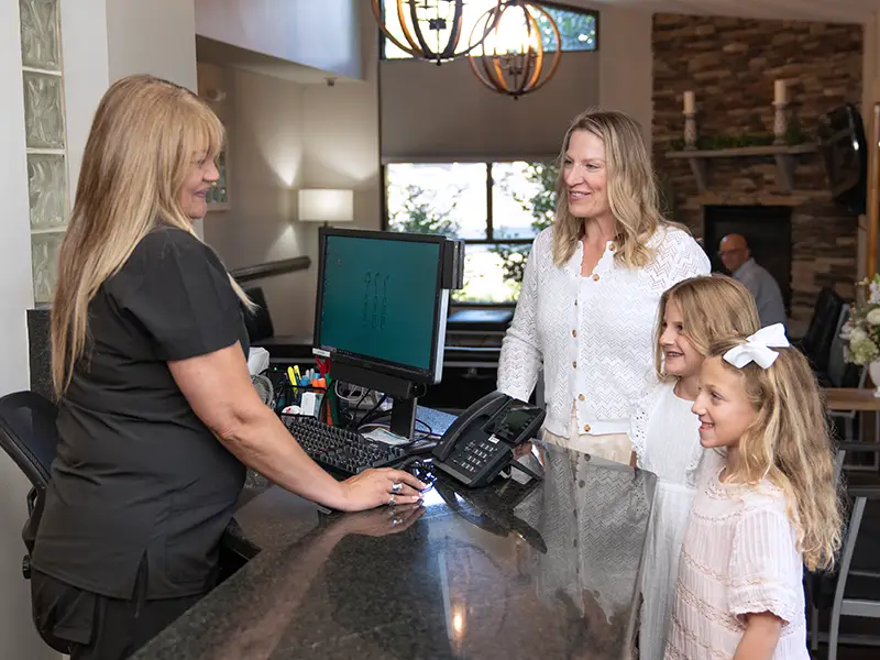 Mother and two daughters at front desk checking in